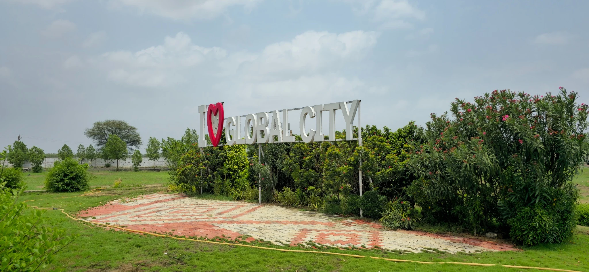 An angled view of the I love Global City sign and the landscaped garden